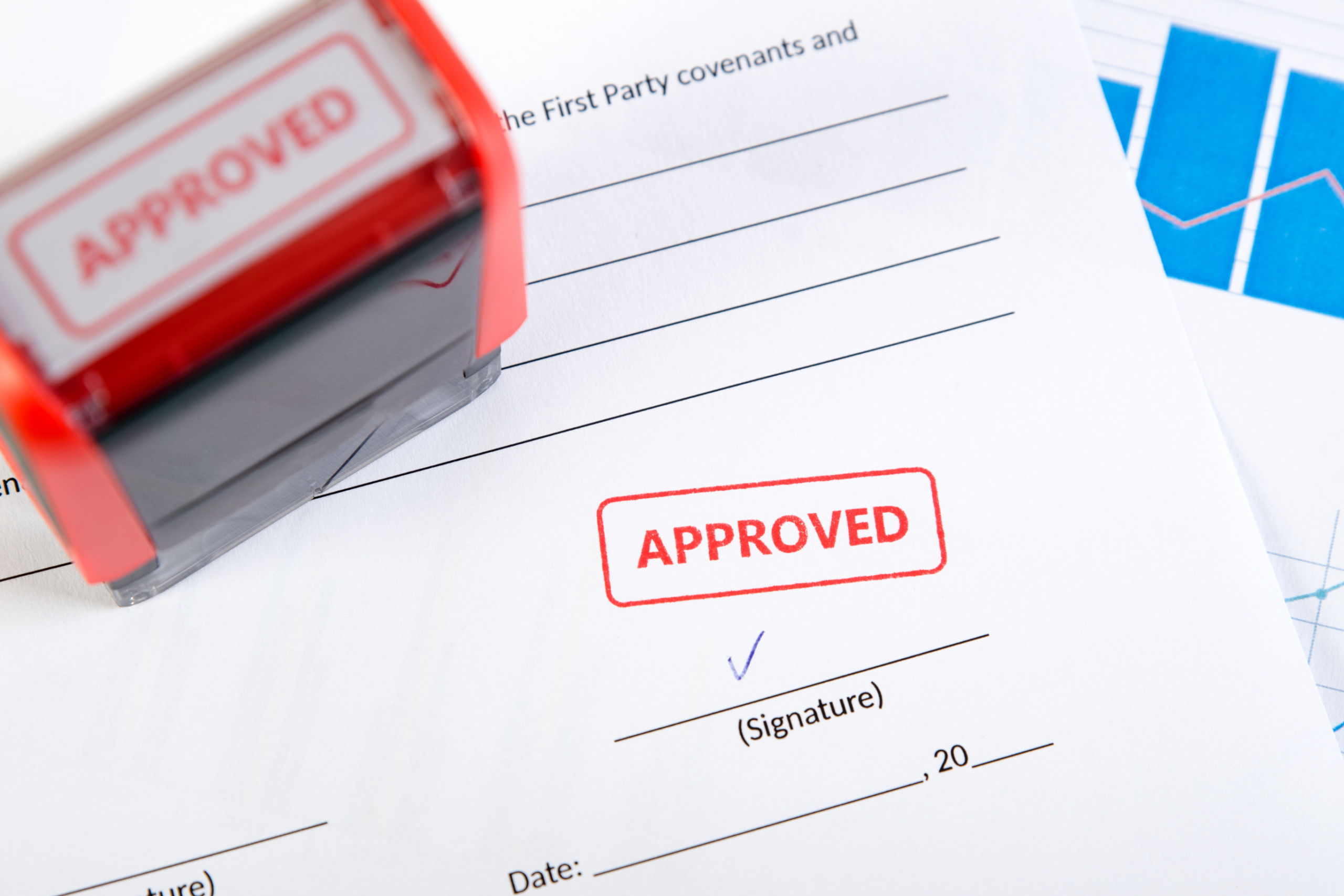Red stamp marked "APPROVED" beside a signed document with a red "APPROVED" stamp and a checkmark on the signature line